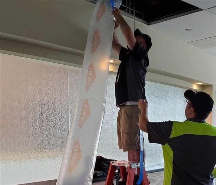 a man pulling desiccant tubing through the ceiling.
